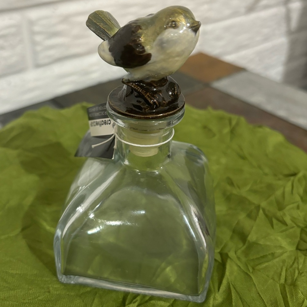 #46 Painted cast iron bird topping a clear bottle by Creative Coop. Beautiful